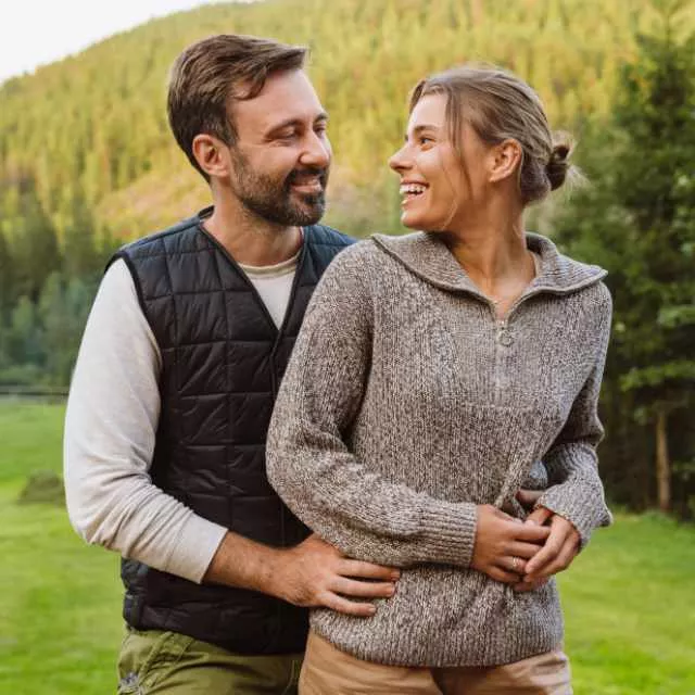 Beautiful couple hugging while standing in Highlands mountains